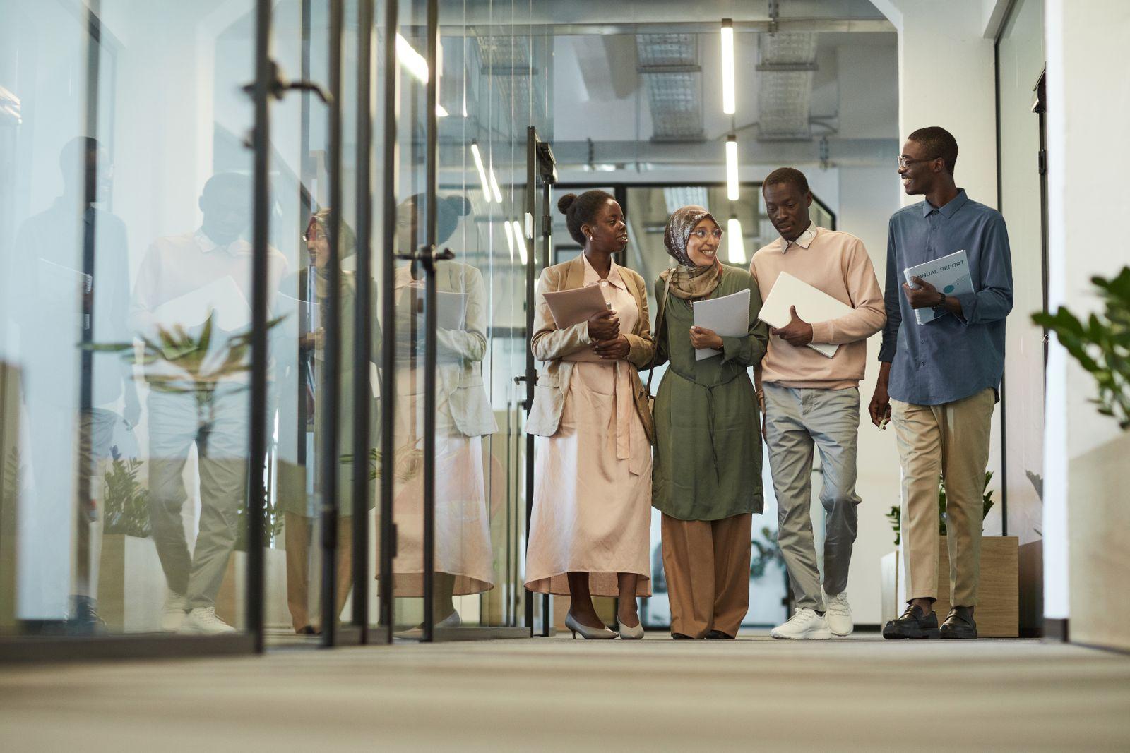 A diverse group of business professionals walking confidently through a modern office
