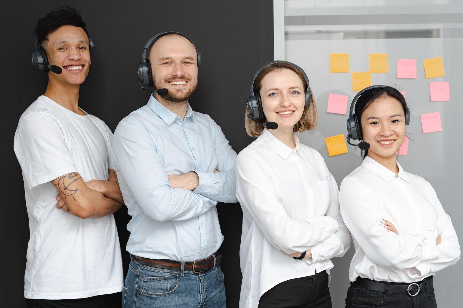 A team of support professionals wearing headsets, smiling confidently