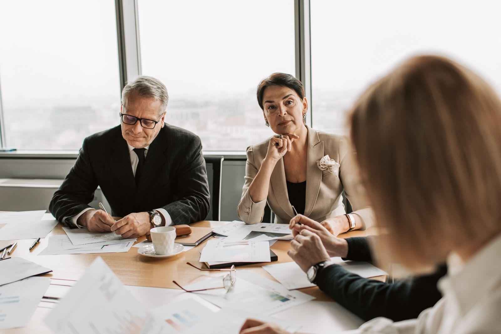 A diverse business team signing an agreement in a modern conference room