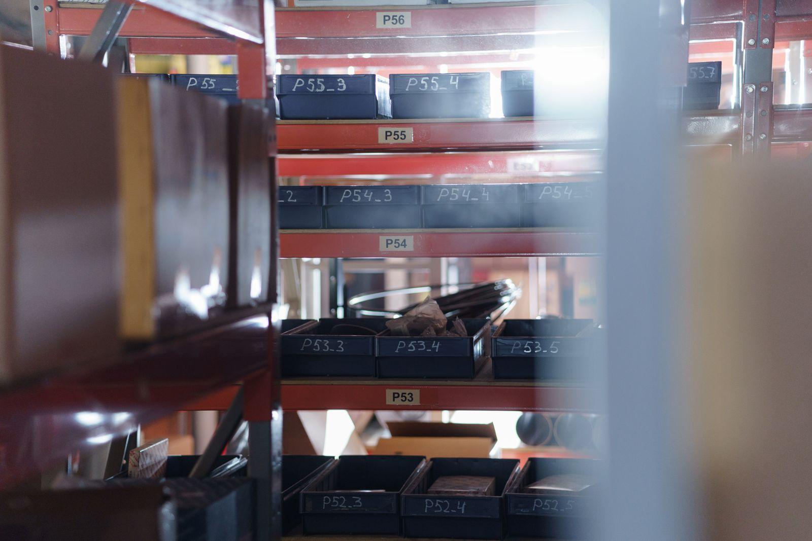 An organized warehouse shelving unit with numbered parts bins